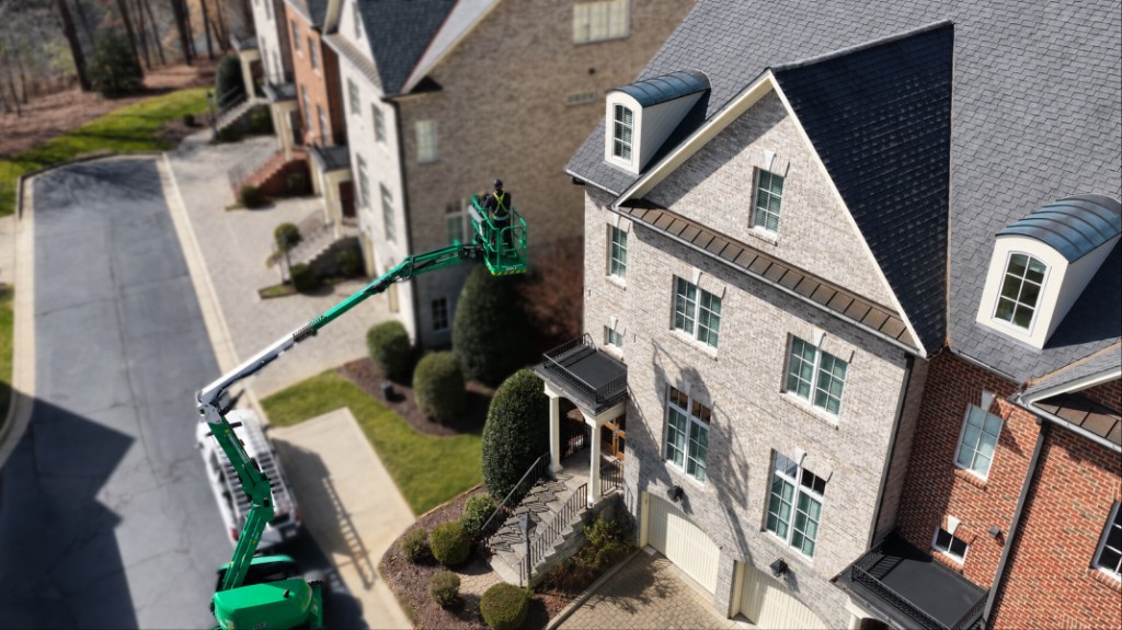 Steep and high roof inspection with aerial lift at residential property